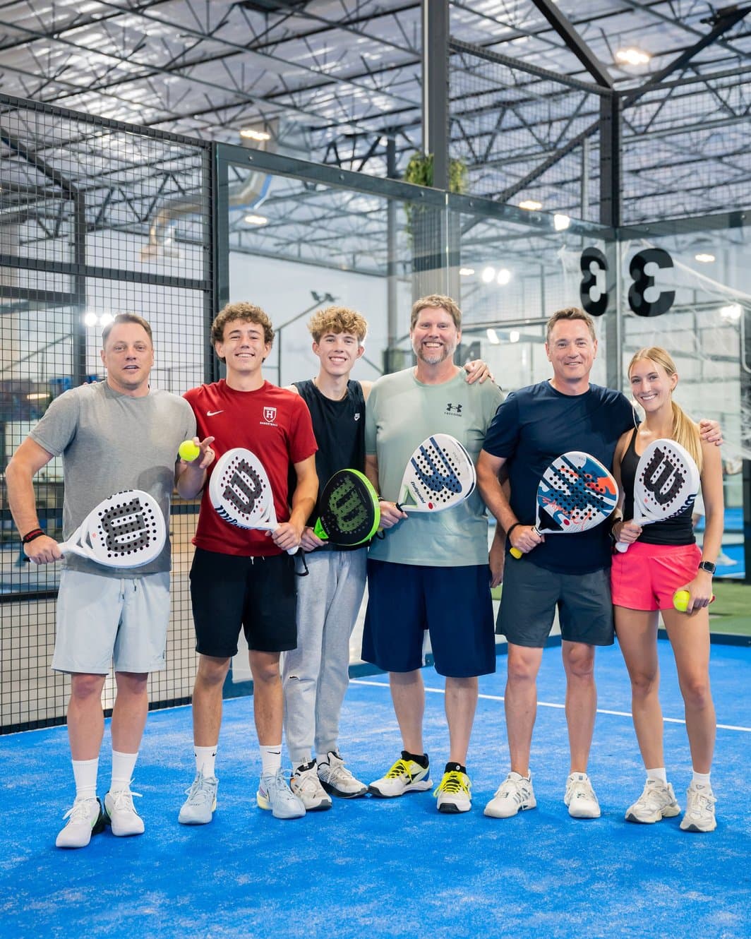 Padel Pals players holding racquets together on an indoor court